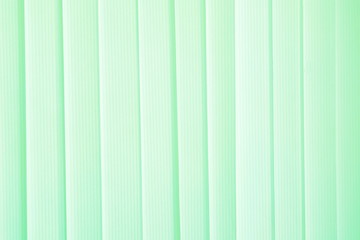 Obraz premium Green ribbons closed the vertical window blinds. Abstract background, seamless texture. Horizontal frame