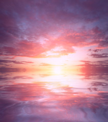 Naklejka na ściany i meble Beautiful fiery sunset and pink-purple clouds over the calm sea.