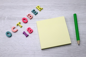 October 18 - Daily colorful Calendar with Block Notes and Pencil on wood table background, empty space for your text or design