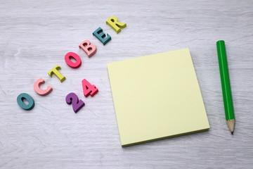 October 24 - Daily colorful Calendar with Block Notes and Pencil on wood table background, empty space for your text or design