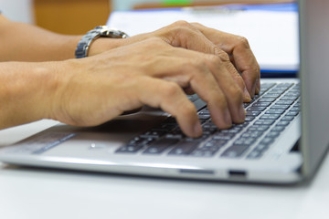 business man typing on laptop keyboard in work office