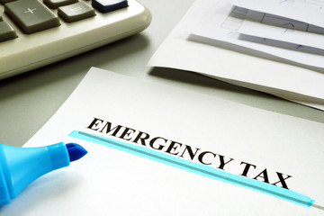 Underlined Emergency tax with financial papers.