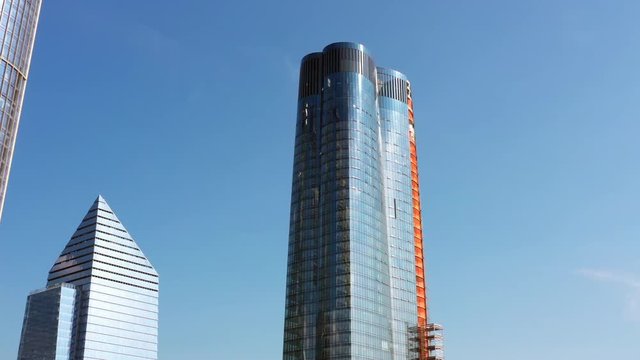 aerial drone orbit of Fifteen Hudson Yards building in Hudson Yards, New York filming the shiny glass reflections of the building and the sun's reflections
