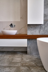 Fototapeta na wymiar Luxury bathroom vanity. Ceramic round sinks placed on teak tabletop in luxury bathroom with gray and white marble walls