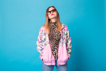 Vintage fashion look concept - pretty young woman wearing a retro jacket and leopard body on blue...