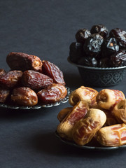 Saudi dates fruits are laid out on a dark table. 