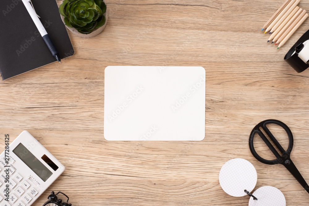 Poster top view blank white paper note with office stationery on wooden table with copy space.student stuff