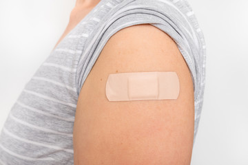 Woman with adhesive bandage on her shoulder