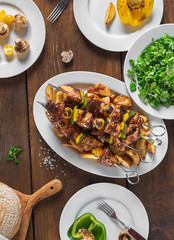 Dinner table concept. Shish kebab, vegetables and salad top view