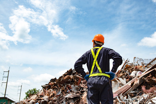 Sanitation Worker Working In Recycling Plant Staff Wearing Reflective Vests In An Industrial Interior