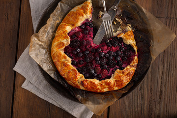 Fruit pie with strawberry, blueberry, blackberry and raspberry on a wooden background top vie