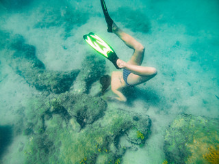 woman with mask and flipper underwater discovering sea bottom