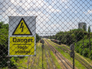 Metal plate on the fence with the inscription. Danger, high voltage