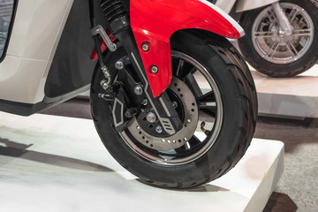 Close-up of electric motorcycle wheel and disc brake system on the auto show stand