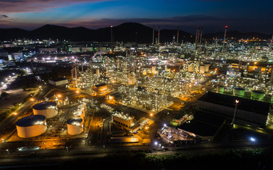 Fototapeta premium Aerial view oil storage tank with oil refinery factory industrial. Oil refinery plant at night. industry factory concept and transportation.