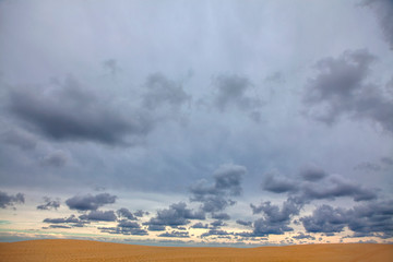 clouds over the sea and sandy dune
