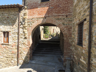 Fototapeta na wymiar Alley of the ancient borgo of Monte del Lago in Umbria, Italy. The village that overlooks the Lake Trasimeno is sorrounded by defensive medieval walls.