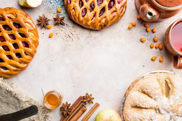 Different homemade pies with ingredients. Crostata - open berry pie and apple pie on a table, top view, from above
