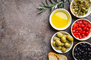 Italian appetizer from above. Mediterranean snack assortment. Black and green olives, capers, olive oil, onion, pepper and garlic top view.