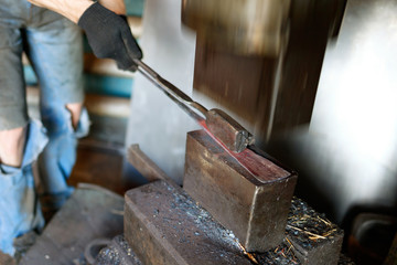 Blacksmith forging by using pneumatic hammer.