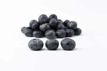 Blueberries in front and a lot of blueberries out of focus in the background - Fresh black blueberries