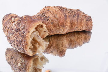 Close-up of a croissant and a half with sesame seeds on top