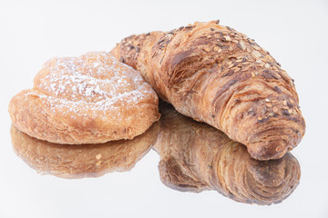 A freshly baked croissant and puff pastry roll