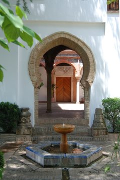 Fountain with Moorish arches to the rear in the Mondragon Palace garden, Ronda, Spain.