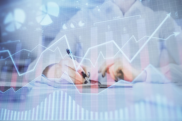 Financial chart drawn over hands taking notes background. Concept of research. Multi exposure