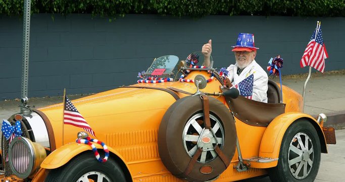 Old patriotic american man cheers people at Independence Day parade in Los Angeles, 4K