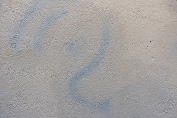 Two color wall with new white paint painted over blue graffiti letters