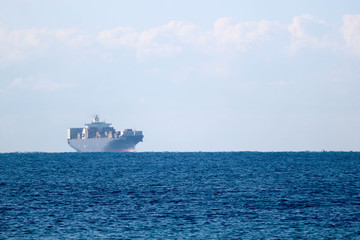 Distant view in haze of a large cargo container ship in the Mediterranean sea