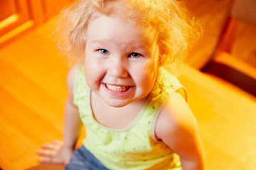 Small girl in the kitchen on the empty table