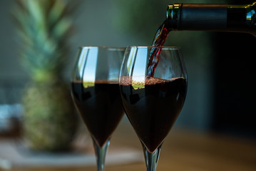 Pouring red wine on a wooden oak table