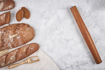 Bread of different varieties on a wood background with copy space background. The concept of bakery, cooking and grocery store.