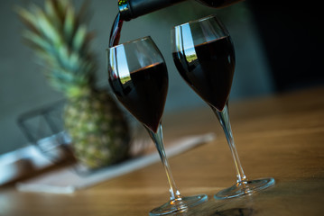Pouring red wine on a wooden oak table