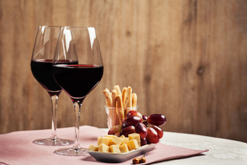 Two glasses of red wine with snacks