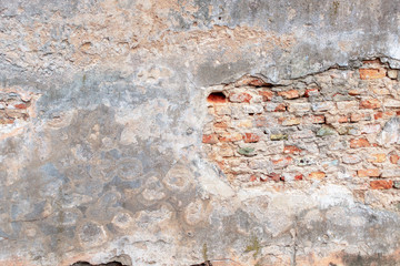Old grungy red brick wall with peeled white beige stucco background. Vintage retro plaster wall with dirty cracked scratched texture background