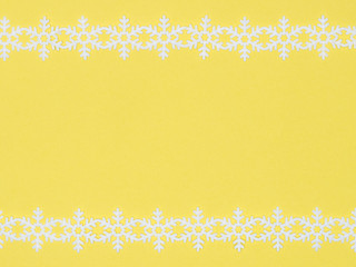White laces snowflake on yellow background. Christmas and New year concept