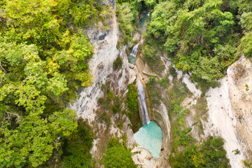 Waterfall in the rainforest jungle from above. Tropical Dao waterfalls in mountain jungle. Philippines, Cebu. Large waterfall in a mountain gorge.