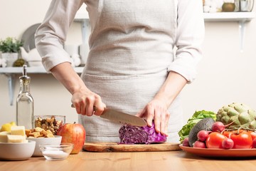 The cook cuts purple cabbage for salad, the concept of tasty and healthy food, diet, vegetarian food, detox