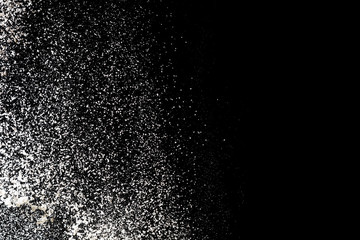 Flour sifting on a black background. White powder splash isolated on black background. Explosive powder white