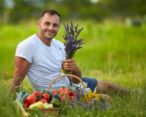 Farmer sitting in the grass with a basket of vegetables