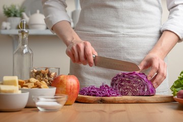 The cook cuts purple cabbage for salad, the concept of tasty and healthy food, diet, vegetarian food, detox