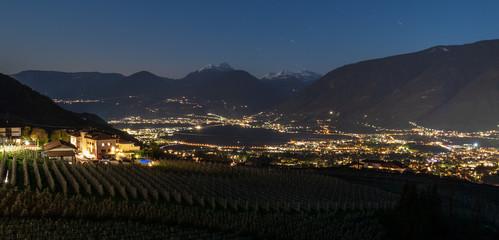 Night Skyline panorama of Meran valley and vineyards of Scena in Burggrafenamt, Meraner Land....