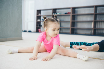 Naklejka premium little girl engaged in recreational gymnastics. sports exercises and stretching: athletics