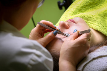 Eyelash extension procedure, woman eye with Long eyelashes