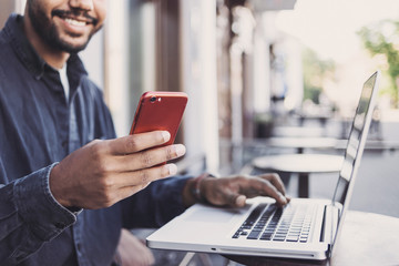 Handsome man using smartphone in a city. Young handsome student men having coffee break and texting on his mobile phone. Modern lifestyle, city life concept