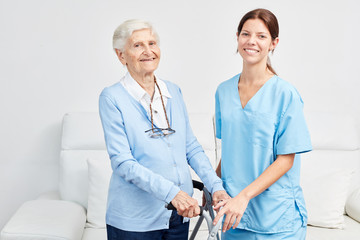 Smiling caregiver with happy elderly woman