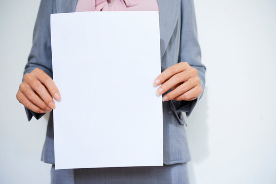Cropped image of female entrepreneur holding blank white paper sheet